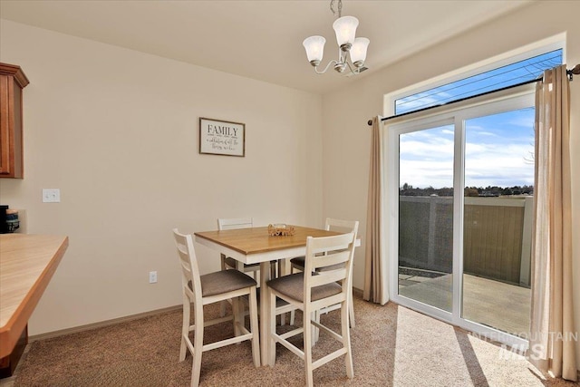 dining space with light colored carpet, baseboards, and a notable chandelier