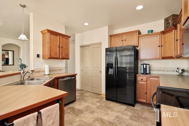 kitchen featuring a sink, range, dishwasher, black refrigerator with ice dispenser, and hanging light fixtures