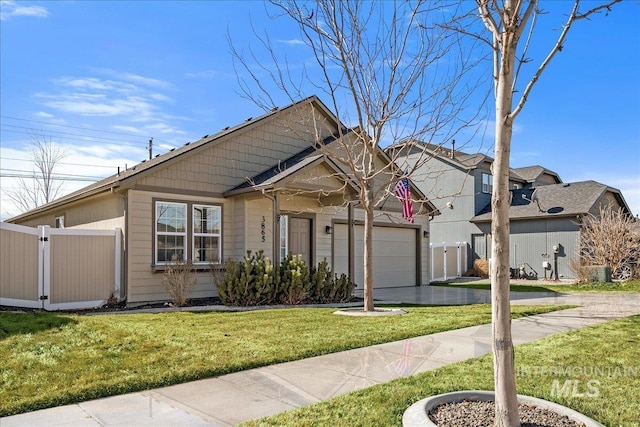 view of front of house with driveway, a gate, fence, a front yard, and a garage