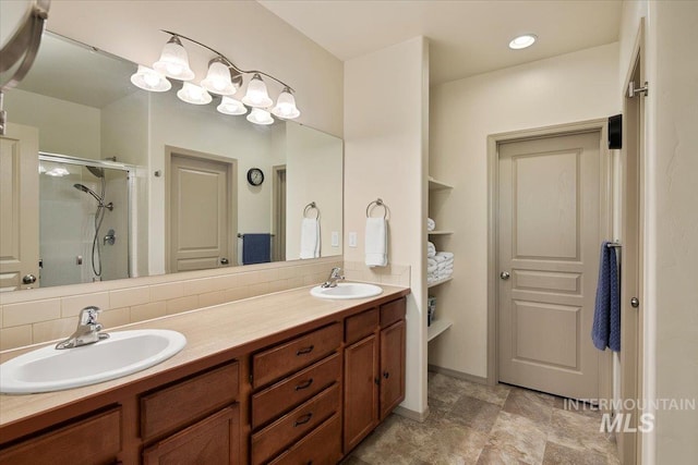 bathroom featuring double vanity, decorative backsplash, a stall shower, and a sink