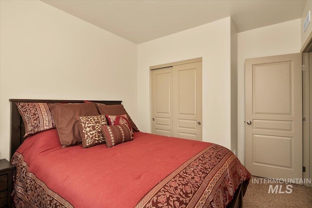 carpeted bedroom featuring a closet and visible vents