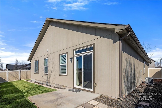 back of house featuring central AC, a yard, a patio area, and a fenced backyard