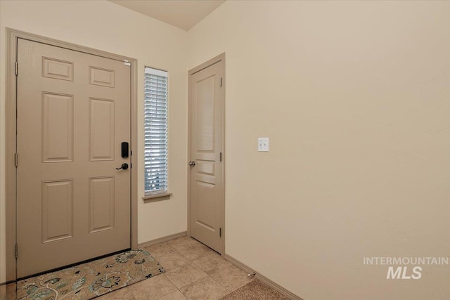 entryway featuring light tile patterned floors and baseboards