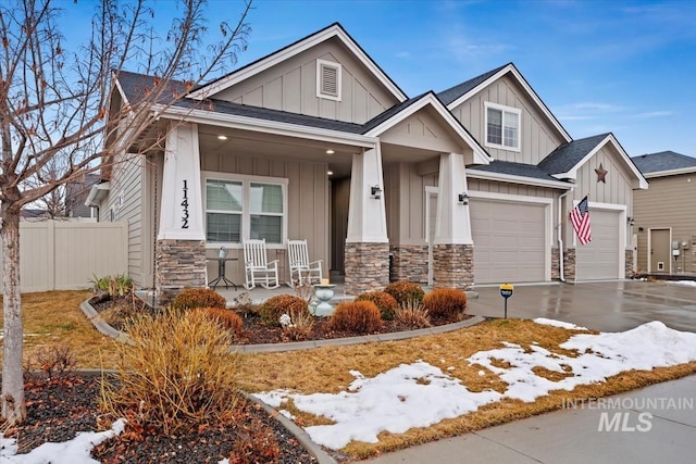 craftsman-style home featuring fence, a porch, board and batten siding, and driveway