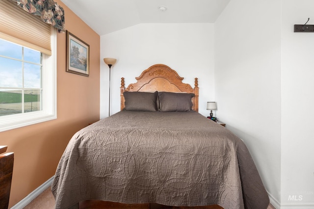 bedroom with baseboards and lofted ceiling