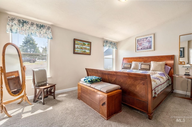 carpeted bedroom featuring lofted ceiling, multiple windows, and baseboards