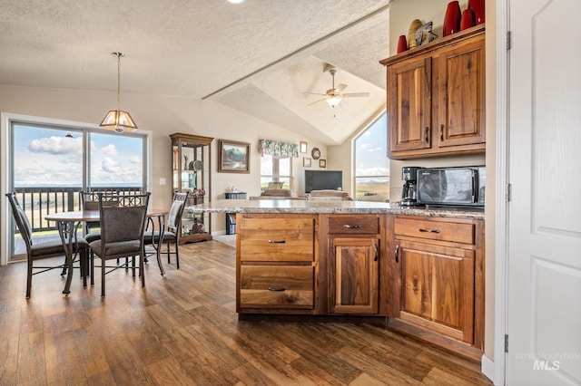 kitchen with dark wood-type flooring, a peninsula, and a textured ceiling