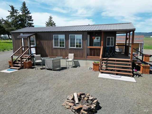 view of front facade featuring an outdoor fire pit and metal roof