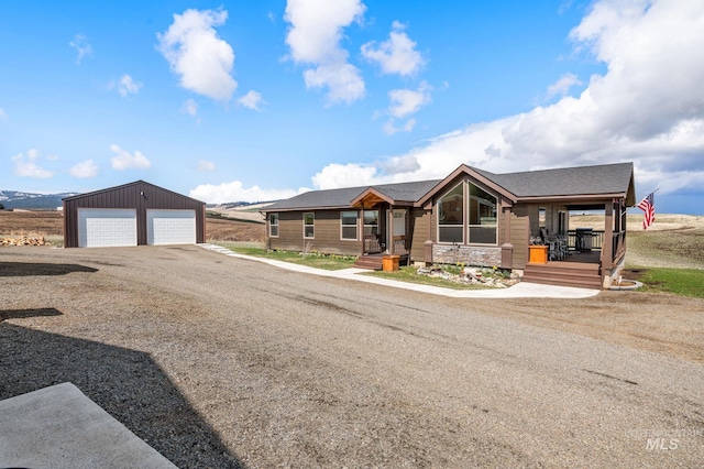 view of front of house with a garage, a porch, and an outdoor structure