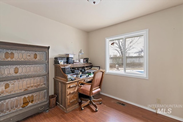 office space featuring visible vents, baseboards, and wood finished floors