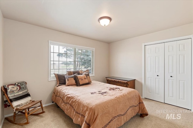 bedroom with light carpet, baseboards, and a closet
