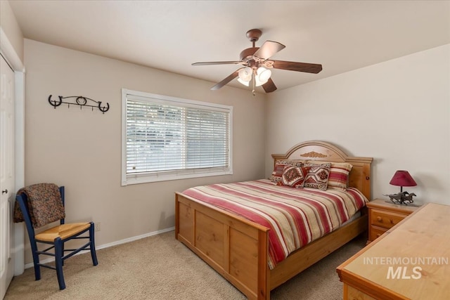 bedroom with light carpet, ceiling fan, and baseboards