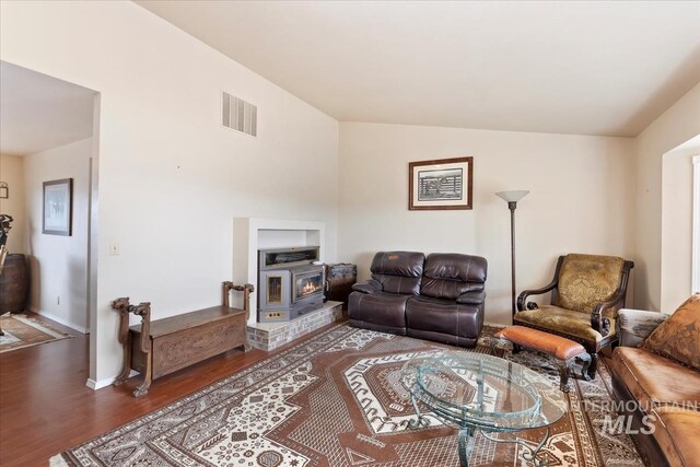 living room featuring visible vents, lofted ceiling, and wood finished floors