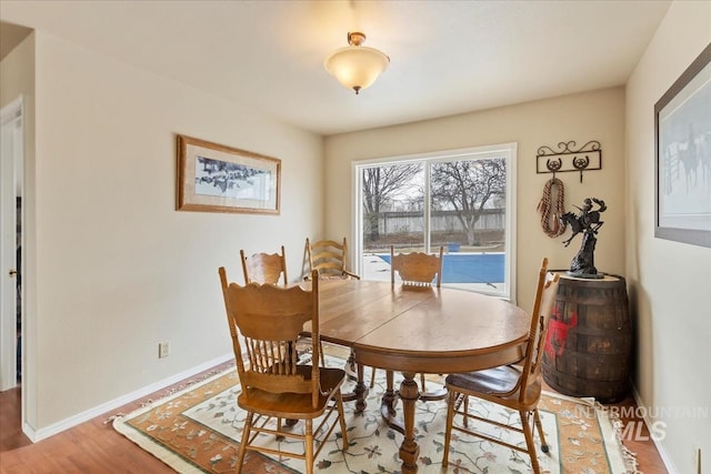 dining room with baseboards and wood finished floors