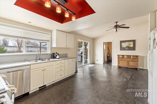 kitchen with baseboards, ceiling fan, a sink, light countertops, and stainless steel dishwasher