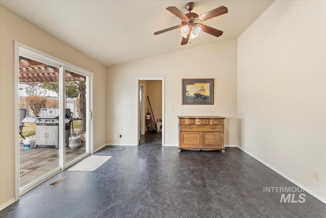 unfurnished room with vaulted ceiling, a ceiling fan, visible vents, and baseboards