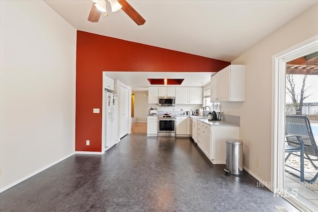 kitchen featuring baseboards, light countertops, vaulted ceiling, appliances with stainless steel finishes, and white cabinets