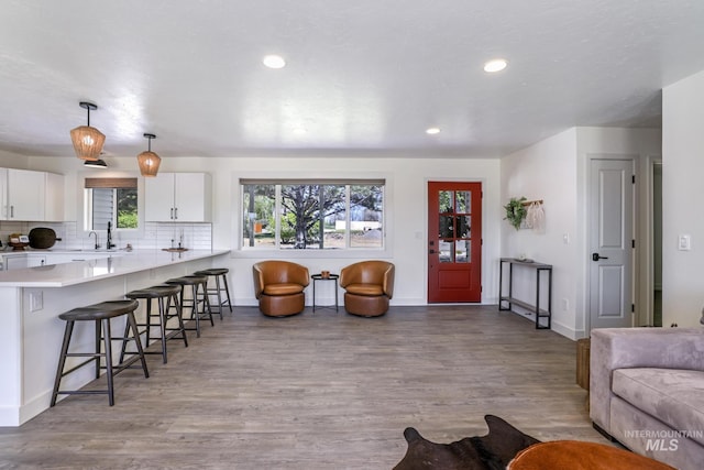 living room with wood finished floors, baseboards, and recessed lighting