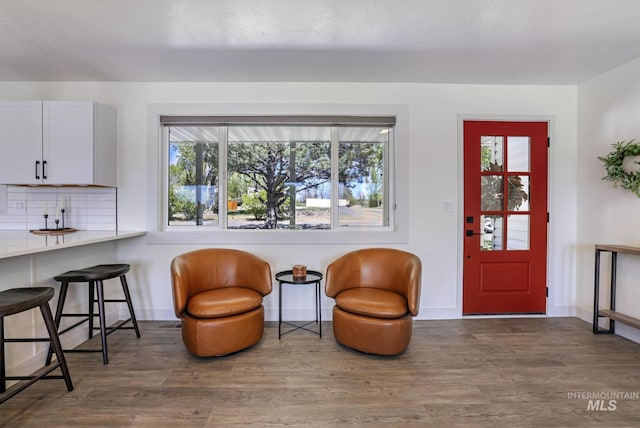 living area featuring baseboards, plenty of natural light, and wood finished floors