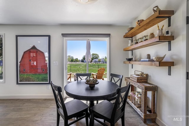 dining area with baseboards and wood finished floors