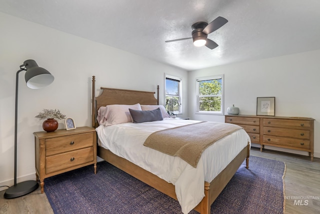bedroom with baseboards, ceiling fan, and wood finished floors