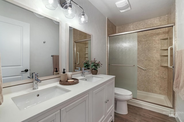 bathroom with a sink, a stall shower, and wood finished floors