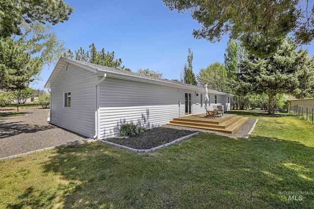 rear view of property with a yard, fence, and a wooden deck