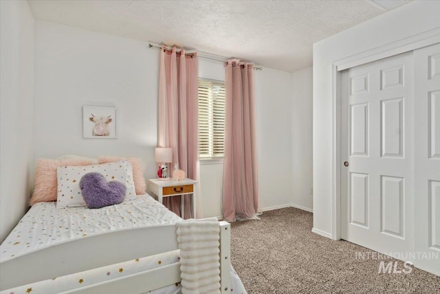 carpeted bedroom featuring a closet, baseboards, and a textured ceiling