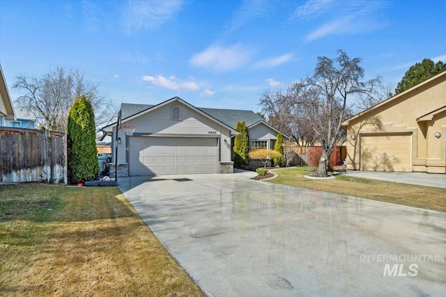 view of front of home featuring a front yard, fence, and a garage