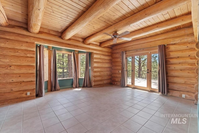 empty room featuring light tile patterned floors, beam ceiling, plenty of natural light, and wood ceiling