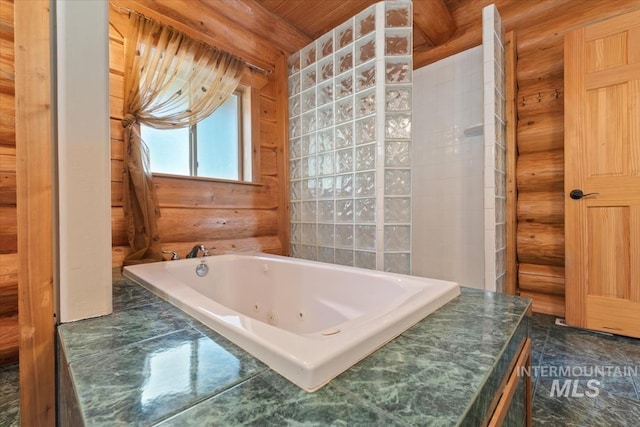 full bathroom featuring a tub with jets and rustic walls
