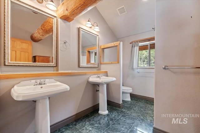 bathroom with visible vents, vaulted ceiling, a sink, baseboards, and toilet