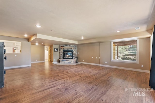 unfurnished living room featuring a fireplace, hardwood / wood-style floors, recessed lighting, baseboards, and visible vents
