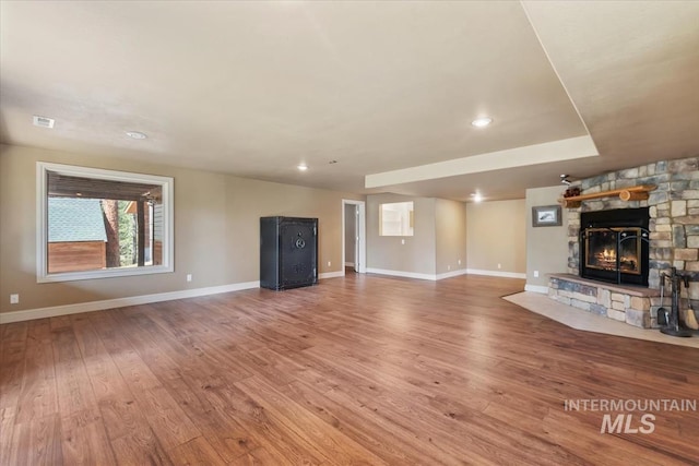 unfurnished living room with visible vents, a fireplace, wood finished floors, baseboards, and recessed lighting