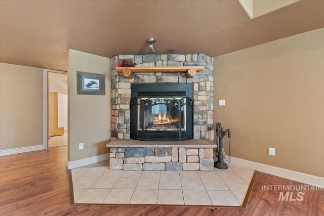 details with baseboards, wood finished floors, and a fireplace