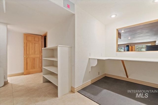 corridor with light tile patterned floors, baseboards, and recessed lighting