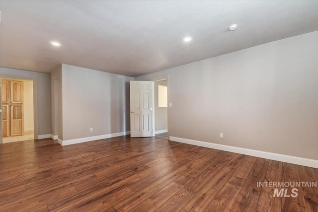 empty room featuring baseboards, recessed lighting, and wood finished floors