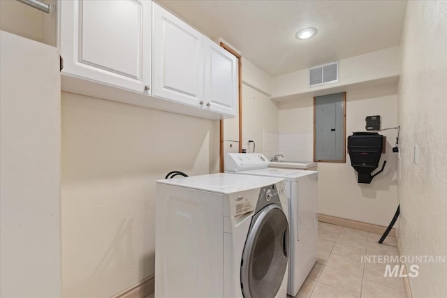 washroom with visible vents, washing machine and dryer, light tile patterned flooring, electric panel, and cabinet space