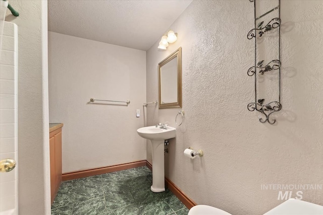 bathroom featuring baseboards and a sink