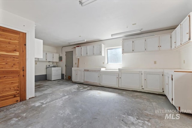 kitchen with washer / dryer, unfinished concrete flooring, and white cabinetry