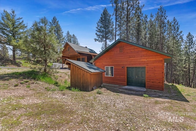back of house featuring an outbuilding
