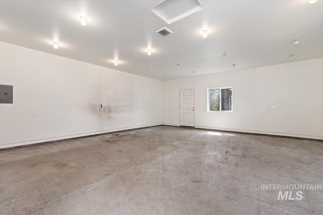 empty room featuring visible vents, concrete floors, and electric panel