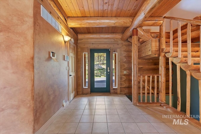 foyer featuring visible vents, rustic walls, beam ceiling, wooden ceiling, and light tile patterned floors