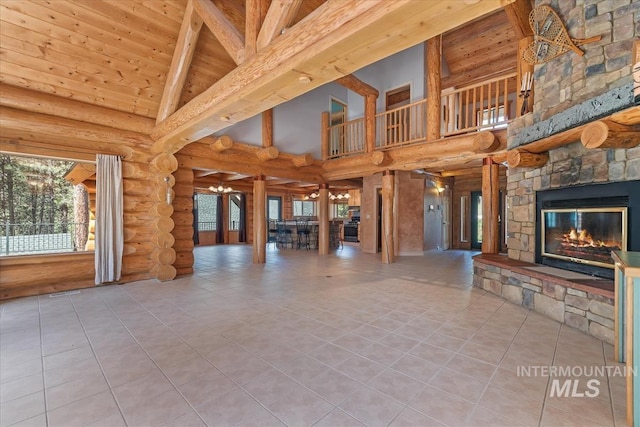 unfurnished living room with tile patterned flooring, log walls, and high vaulted ceiling