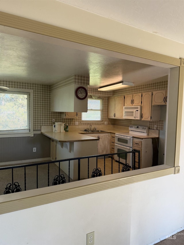 140 Quick Silver Ave, Hagerman, ID 83332 - kitchen with white appliances, a sink, light countertops, and a peninsula