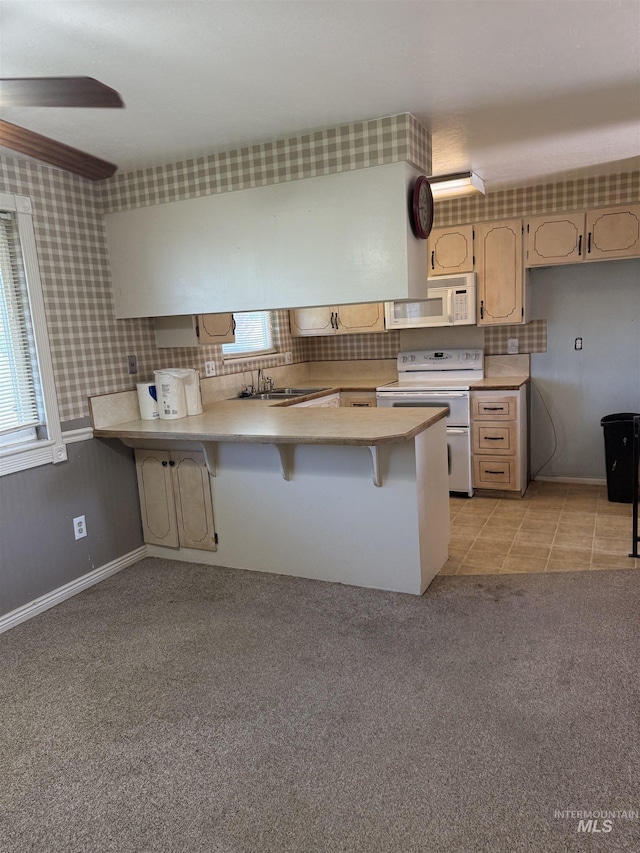 140 Quick Silver Ave, Hagerman, ID 83332 - kitchen with white appliances, a peninsula, light countertops, a kitchen breakfast bar, and a sink