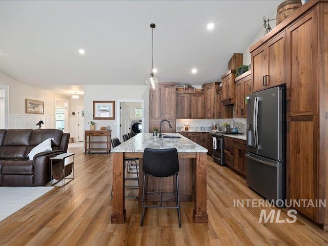 138 Williams Way, Jerome, ID 83338 - kitchen with stainless steel appliances, a breakfast bar, washer / clothes dryer, open floor plan, and light stone counters