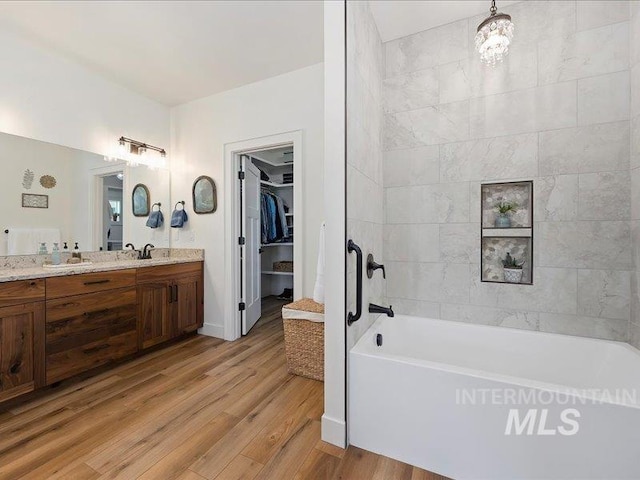 138 Williams Way, Jerome, ID 83338 - full bathroom with vanity, wood finished floors, a walk in closet, and tub / shower combination