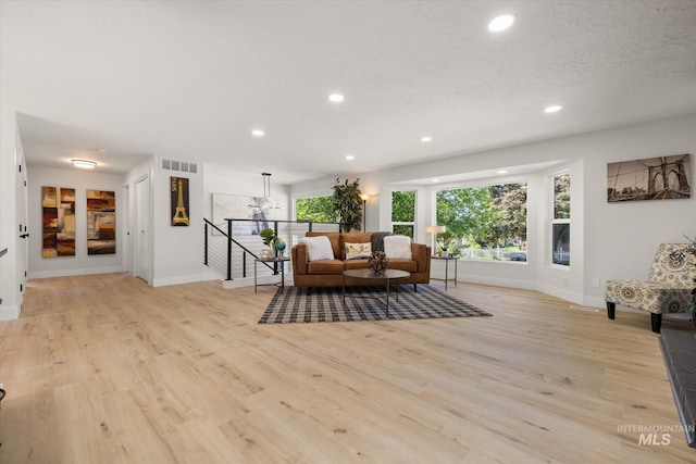 living room with light wood finished floors, baseboards, recessed lighting, and a textured ceiling