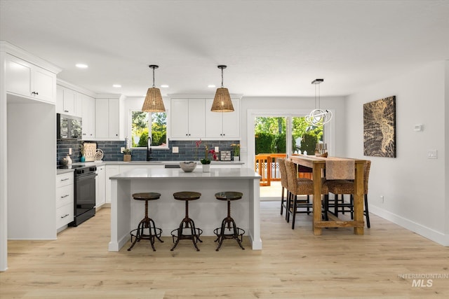 kitchen featuring black range with electric stovetop, healthy amount of natural light, decorative backsplash, and recessed lighting